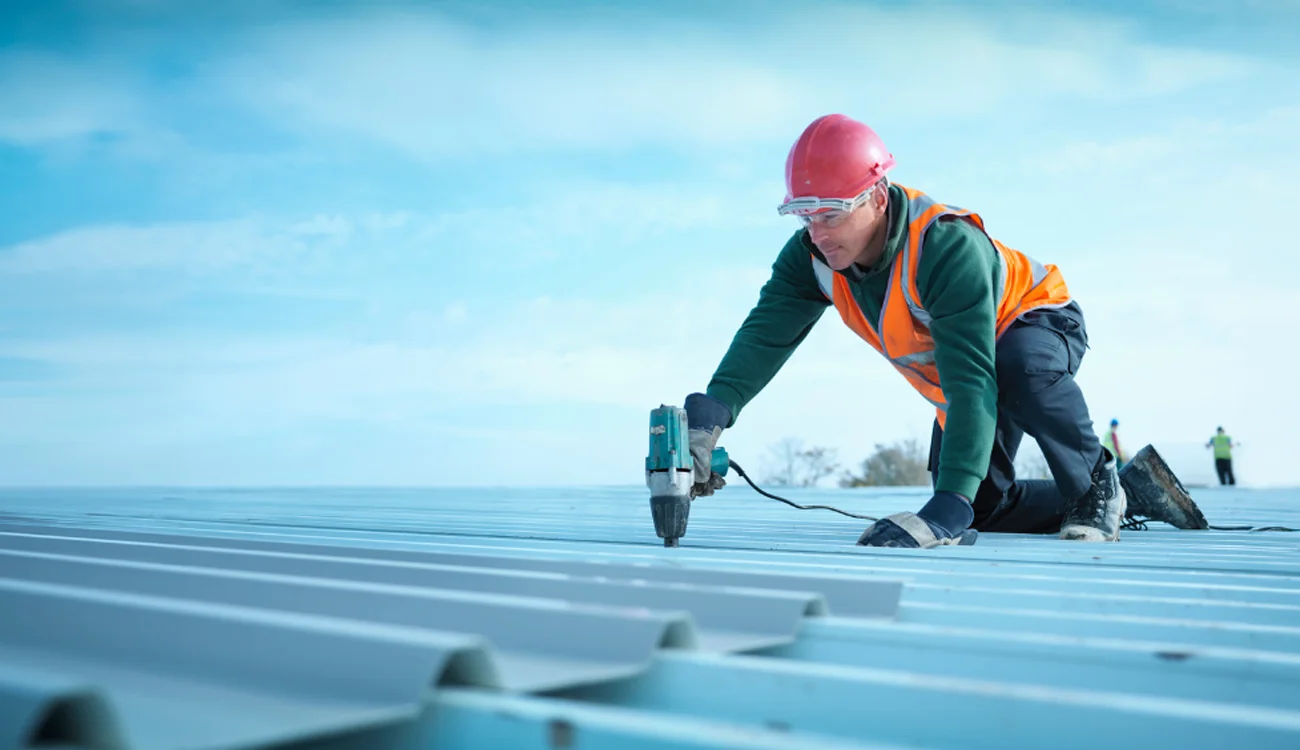Roofer atop a factory building