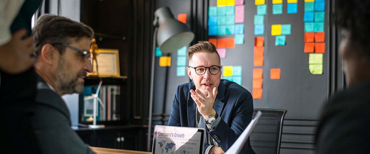 Business Meeting mit mehreren Personen, im Hintergrund Mood Board mit Post-its