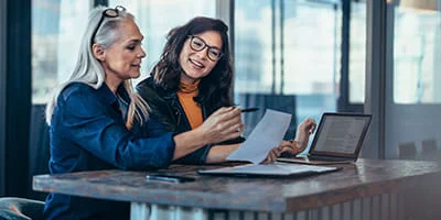 Zwei Kollegen analysieren einen Geschäftsbericht